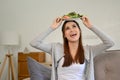 Joyful Asian female putting a plate of her green salad on her head. Healthy and wellbeing lifestyle Royalty Free Stock Photo