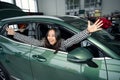 Joyful asian female sitting in new car