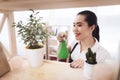 Asian housewife spraying plants at home.