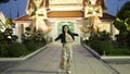 Joyful Asian woman walking alongside the Buddhist temple - slow moton shot