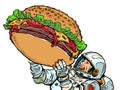 Joyful astronaut man and a huge burger. Street food fast food. Hungry man Happiness positive smile