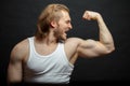 Joyful athlete admiring with his strong arms isolated on the black background Royalty Free Stock Photo