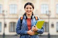 Joyful attractive Indian woman student standing outside her college