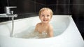 A joyful baby boy giggles and splashes in his bathtub, surrounded by a bubbly foam that creates a playful and relaxing atmosphere