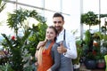 Happy young couple standing in flower shop Royalty Free Stock Photo