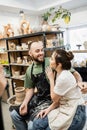 Joyful bearded sculptor in apron hugging