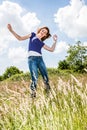 Joyful beautiful young girl jumping, dancing in high dry grass Royalty Free Stock Photo