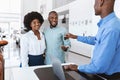 Joyful black couple purchasing new auto, taking car key from salesman at automobile dealership Royalty Free Stock Photo