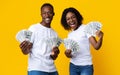 Joyful black couple won lottery, showing prize at camera, screaming