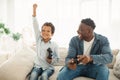 Joyful Black Daddy And Son Winning Online Video Game Indoor