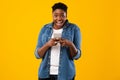 Joyful Black Female Using New Smartphone Standing Over Yellow Background Royalty Free Stock Photo