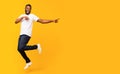 Joyful black guy jumping up and pointing aside Royalty Free Stock Photo