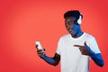 Joyful black guy listening to music online, using smartphone, headphones Royalty Free Stock Photo