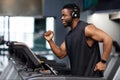 Joyful black man in modern wireless headphones running at gym Royalty Free Stock Photo