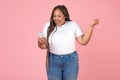 Joyful Black Oversized Woman Using Smartphone Gesturing Yes, Pink Background