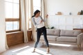 Joyful black woman dancing in living room