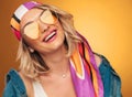 joyful blonde woman with yellow sunglasses and colored scarf laughs