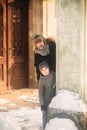 A joyful boy in a coat is playing with father in winter