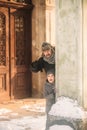 A joyful boy in a coat is playing with father in winter