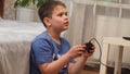 Joyful boy playing video games and laughing seated at home