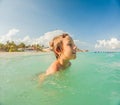 Joyful boy plays in the sea, creating playful splashes and enjoying the waves Royalty Free Stock Photo