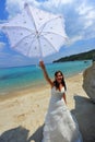 Joyful bride on exotic beach holding her umbrella Royalty Free Stock Photo