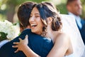 Joyful bride hugging groom. Beautiful young mixed race woman looking happy after marrying her soulmate