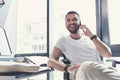 Joyful bristled manager having pleasant conversation on mobile phone Royalty Free Stock Photo