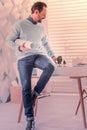 Joyful brunette man sitting on the table