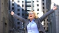 Joyful business lady showing yes gesture raising hands up, goal achievement