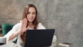 Joyful business woman making web call on laptop camera in modern office. Royalty Free Stock Photo