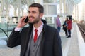 Joyful businessman calling by phone from train station Royalty Free Stock Photo