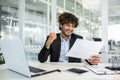 Joyful businessman celebrating success at office desk Royalty Free Stock Photo