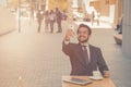 Joyful businessman holds an online meeting using mobile phone. Handsome man talking to partners or taking selfie while Royalty Free Stock Photo