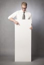 Joyful businessman pointing finger at white empty panel. Royalty Free Stock Photo