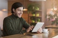 Joyful businessman reading news on digital tablet at cafe Royalty Free Stock Photo