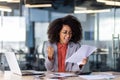 Successful young businesswoman celebrating achievement at office desk Royalty Free Stock Photo