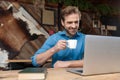 Joyful casual man reading, laughing, and drinking his coffee Royalty Free Stock Photo
