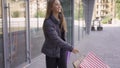 Joyful caucasian girl walking on the street with shopping bags. Happy woman satisfied with her purchases. Shopaholism.