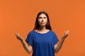 Joyful caucasian woman in blue t-shirt show woh to concentrate and find right solution or way out in crisis situation, makes mudra Royalty Free Stock Photo