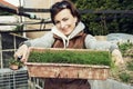 Joyful caucasian woman with pot of chive in the garden