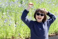 Joyful child with blue sunglasses laughing for being in nature