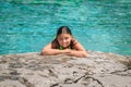 Joyful child girl lying and relaxing on the edge of the cliff against gorgeous amazing Cyprus lake background