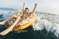 Child on inflatable ring ride on breaking wave. Travel lifestyle, swimming activities. Selective focus