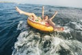 Child on inflatable ring ride on breaking wave. Travel lifestyle, swimming activities. Selective focus