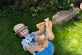 joyful child lies on the lawn, his bare feet tickled by a large ostrich feather Royalty Free Stock Photo