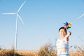 Boy's playful fascination near wind turbines holding a pinwheel toy Royalty Free Stock Photo