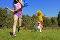 Joyful children a boy and a girl with blue and yellow hair play with a dog on a lawn in nature