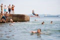 Joyful children jumping and diving into the sea from old dock Royalty Free Stock Photo