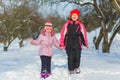 Joyful children playing in snow. Two happy girls having fun outside winter day Royalty Free Stock Photo